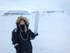 Out in the field (Rebecca Duncan): Rebecca Duncan with a typical ice core after the ice algae have been extracted.